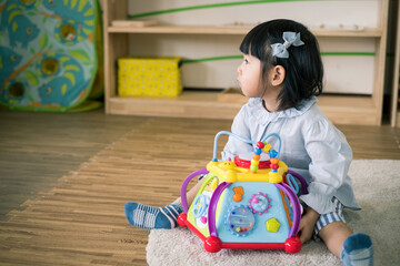 A toddler girl is playing toy.