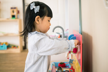 A toddler girl is playing kitchen toy. - 424819739