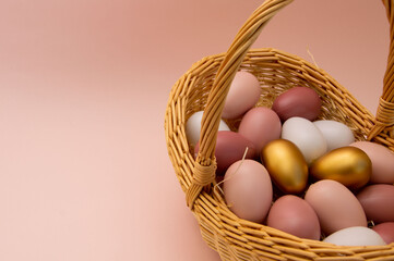 Easter eggs in a basket on a pink background. Postcard with place for your text