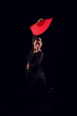 flamenco woman with black dress and red fan above her head - obrazy, fototapety, plakaty