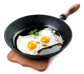 Fried eggs in a frying pan on a kitchen board on a white background. Isolated