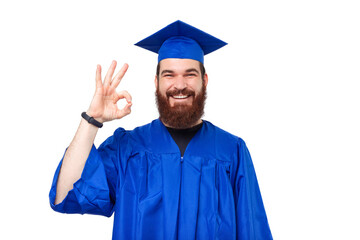 Photo of cheerful student man graduating and showing ok gesture