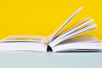 A open book on a yellow-blue background. The concept of education