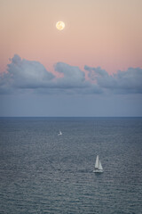 A beautiful setting moon over a sailboat and the Atlantic Ocean. Florida, USA. - 424828567