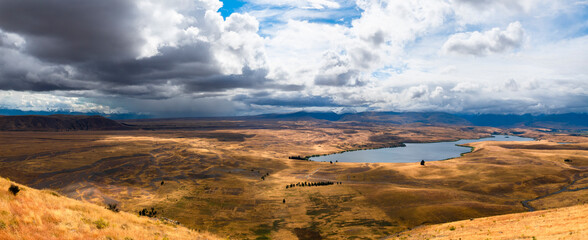 Naklejka premium New Zealand dry meadow in autumn with dramatic sky