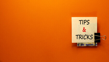 Tips and tricks symbol. White paper clip with dollars cash money. Words 'Tips and tricks'....