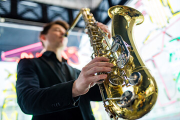 Obraz na płótnie Canvas Male jazz musician playing a saxophone in a restaurant
