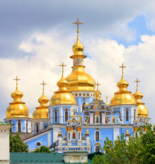 Fototapeta na wymiar Golden domes of St. Michael's Golden-Domed Cathedral in Kiev in the spring against a blue cloudy sky on a warm spring day.