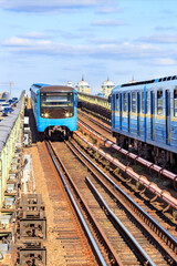 Two metro trains travel on rails towards each other along the Kyiv metro bridge across the Dnipro River.