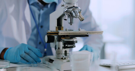 Medical laboratory. Young scientist examining microbiology tests developing vaccine with microscope...