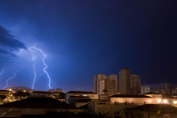 Lightning in the blue sky of the city of Santos.