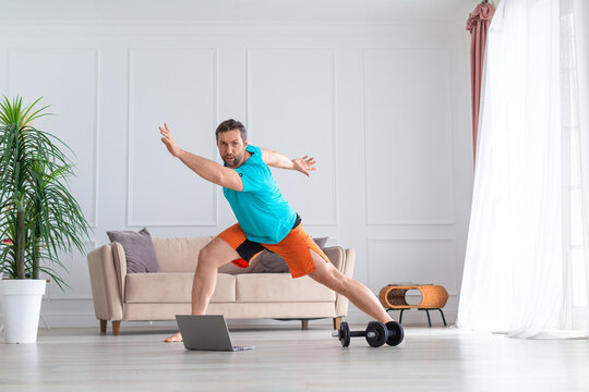 Photo pf a middle-aged man during online aerobic workout. Home workout concept.