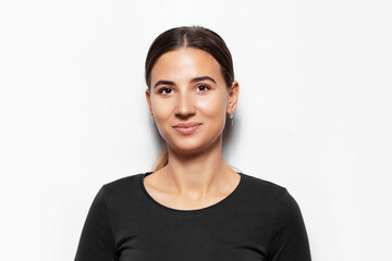 Studio portrait of young smiling brunette girl on white background.