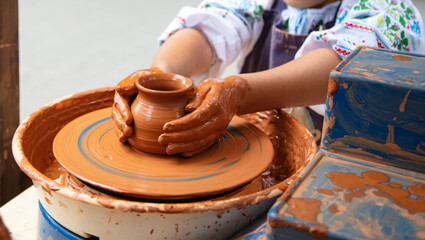 Closeup of hands of young girl making pottery