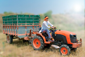 
Indian Asian farmer with tractor preparing land for sowing with cultivator, An Indian farming scene
