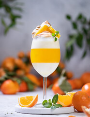 Italian dessert panna cotta with tangerine jelly layer in a glass