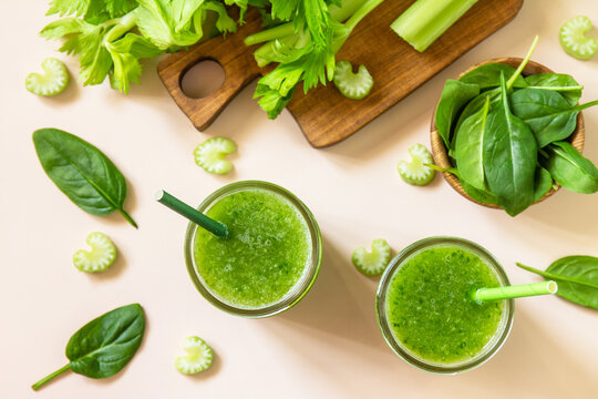 Vegan smoothie recipe. Healthy diet and nutrition, vegan and alkaline drink. Green fresh smoothie with celery and spinach on a pink background. Top view. Flat lay.