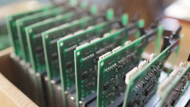Slider shot video of a large green microcircuit with connectors in a military equipment factory. The concept of new technologies in production