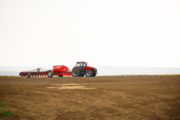 Obraz premium Large modern tractor for preparing the field after winter for sowing grain. Agricultural machinery