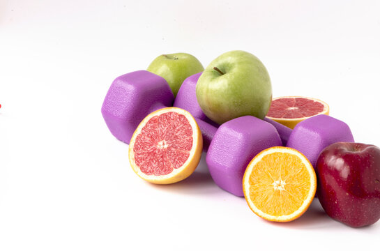 A Pair Of Purple Dumbbells With Fresh Fruit For A Healthy Lifestyle And Women's Health Support