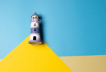toy lighthouse on the mount on coast of the sea paper background
