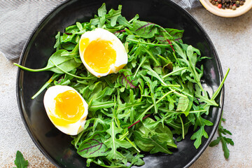 healthy salad lettuce leaves mix arugula, chard and poached egg trend meal copy space food background rustic. top view keto or paleo diet vegan or vegetarian food