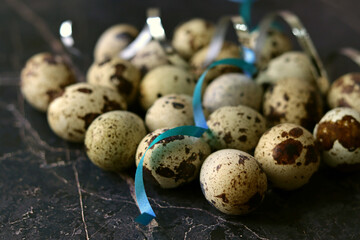 Obraz premium Close-up view of fresh raw quail eggs over blue concrete stone or marble backround. Top view