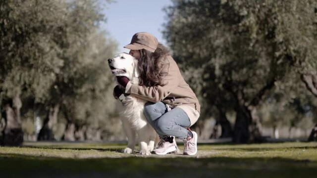 Mixed race woman with golden retriever in the woods