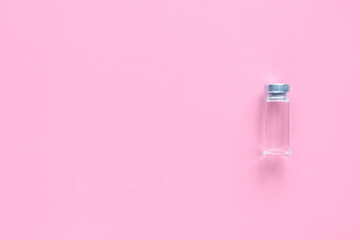 Ampoule of vaccine on pink background.