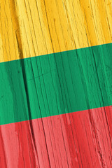 The flag of Lithuania on dry wooden surface, cracked with age. Vertical background, wallpaper or...