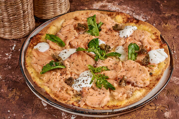 pizza con salmon sobre una mesa rustica