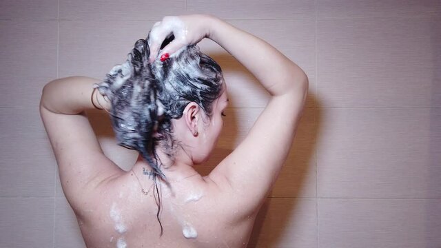 Woman washes her hair with shampoo in the shower with, hair care, ceratin mask, rinse shampoo and balm, strong hair, washing hair