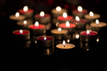 background with tea light candles shines in the dark.
