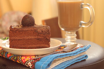 sweet delicious chocolate cake on a plate with coffee with milk