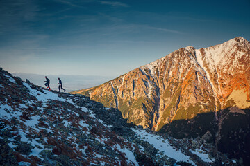 Two trail runners silhouette on morning run in mountains. Sport photo, active morning, exercise and training with first sun. Sport in High Tatras, Slovakia