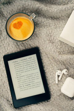 E-book reader, a cup of coffee with heart design and a headset