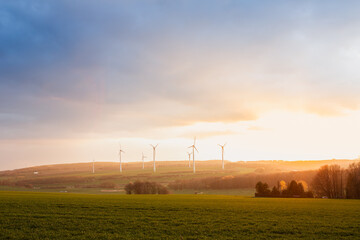 Beautiful landscape sunset with wind turbines in the countryside during the beginning spring season