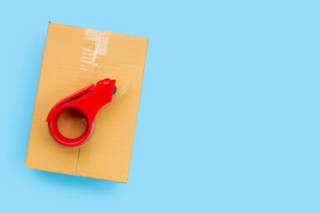 Parcel tape dispenser on cardboard box