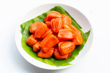 Ripe red Jackfruit on banana leaves on white