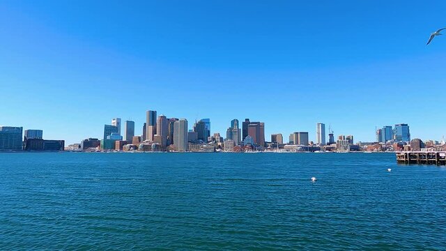 Time lapse of Boston financial district skyline including historic Custom House and Boston Harbor from East Boston, Massachusetts MA, USA. 