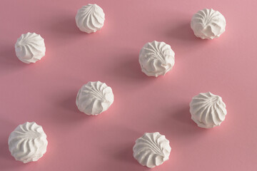 White airy  sweet marshmallow on a pink background. Horizontal photo from above, background - food concept.