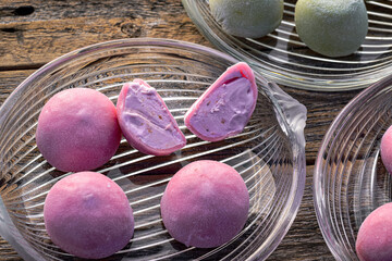 whole pink strawberry flavor mochi ice cream and one cut in half on glass plate - 424857392