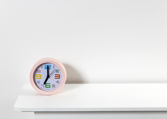 Pink alarm clock on a white table. Scandinavian style