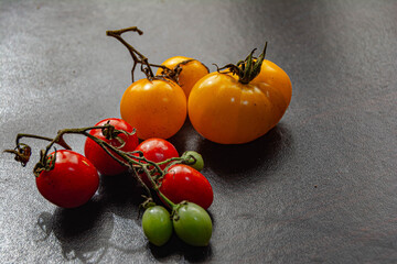 tomates de diferentes colores sobre plataforma de color negro