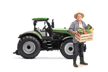 Elderly farmer with a tractor carrying a wooden crate full of vegetables