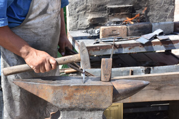 Blacksmith forged ironsmith. traditional hammer beating. Medieval blacksmith. Horseshoe workspace made with the medieval blacksmith method.