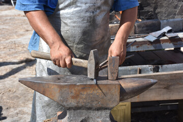 Blacksmith forged ironsmith. traditional hammer beating. Medieval blacksmith. Horseshoe workspace made with the medieval blacksmith method.