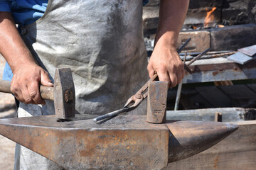Blacksmith forged ironsmith. traditional hammer beating. Medieval blacksmith. Horseshoe workspace made with the medieval blacksmith method