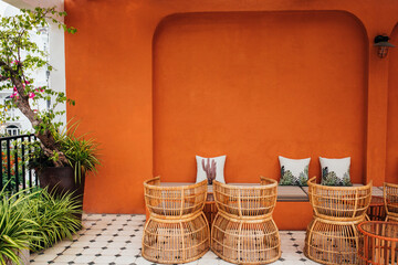 pillows against the background of an orange textured wall with a striped sofa in a modern cafe,...
