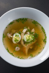 Freshly cooked chicken broth, bullion, soup with eggs and herbs